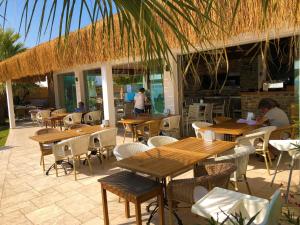 a restaurant with wooden tables and chairs and a building at Zest Exclusive Hotel & Spa in Ortakent