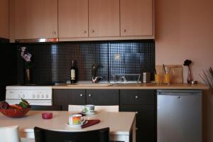 a kitchen with a sink and a table with a bottle of wine at Yasoo Holiday Apartments in Olympiada