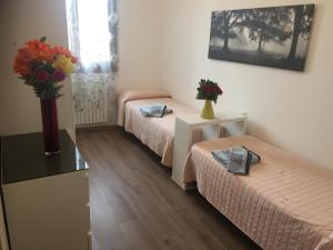 a room with two beds and a vase of flowers on a table at TINTORETTO 1 CON TERRAZZA SOPRA IL TETTO, 3 bagni, 3 grandi camere da letto, SUPER NUOVO in Venice