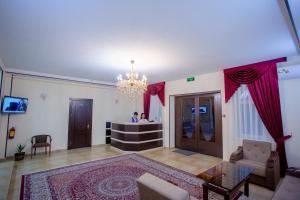 ein Wohnzimmer mit einem Kronleuchter und einem Tisch in der Unterkunft Orient Palace in Taschkent