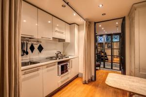 a kitchen with white cabinets and a table at Magenta Collection Specchi in Rome
