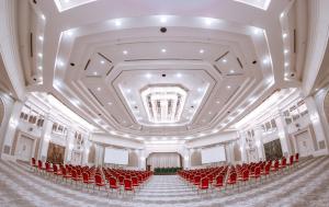 una habitación vacía con sillas rojas y techo en International Hotel Tashkent, en Tashkent