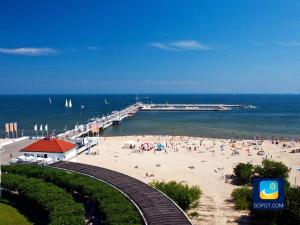 plaża z ludźmi na piasku i molo w obiekcie Sea Sail Apartments w mieście Sopot