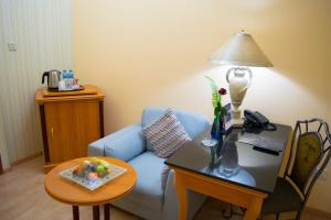 a living room with a blue couch and a table with a lamp at The Royal Express Sharq in Kuwait