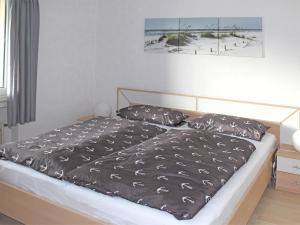 a bed with a black comforter in a bedroom at Beautiful apartment in Bodenwerder with balcony in Bodenwerder