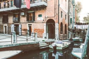 un bateau dans un canal devant un bâtiment dans l'établissement Industrial Loft Venice R&R, à Venise
