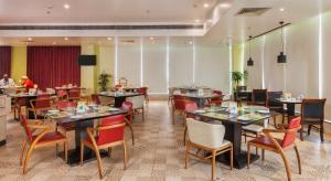 a restaurant with tables and chairs and people in the background at Lemon Tree Premier, Patna in Patna