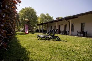 two benches sitting in the grass next to a building at Agriturismo Lupo Bianco in Monzambano