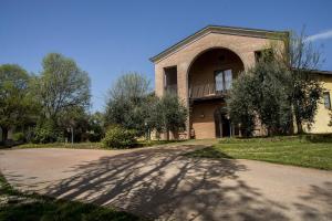 a large brick house with a driveway in front of it at Agriturismo Lupo Bianco in Monzambano