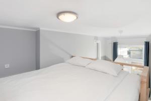 a bedroom with a white bed and a window at Apartments Poznań MTP by Renters in Poznań