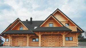 a log cabin with a black roof at Dwór Pan Tadeusz in Orawka