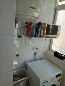 a small kitchen with a microwave and a washing machine at Desconecta a pocos metros de playa y ocio in Los Alcázares