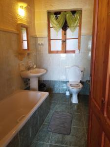 a bathroom with a tub and a toilet and a sink at Ta' Karkar Villa Bed and Breakfast in Xagħra