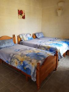 シャーラにあるTa' Karkar Villa Bed and Breakfastのベッド2台が隣同士に設置された部屋です。