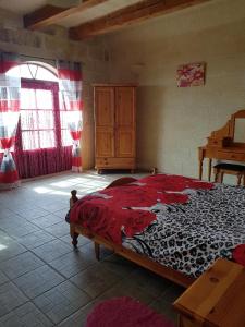 ein Schlafzimmer mit einem großen Bett in einem Zimmer in der Unterkunft Ta' Karkar Villa Bed and Breakfast in Xagħra
