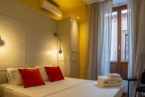 a bedroom with a bed with red and white pillows at Apartamento moderno junto a la Gran Via in Madrid