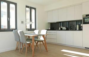 a kitchen with white cabinets and a table and chairs at Baabe Villa Andrea Ferienwohnung M in Baabe