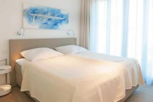 a bedroom with a bed with a white blanket at Baabe Villa Andrea Ferienwohnung M in Baabe