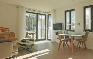 a living room with a table and chairs and a couch at Baabe Villa Andrea Ferienwohnung M in Baabe