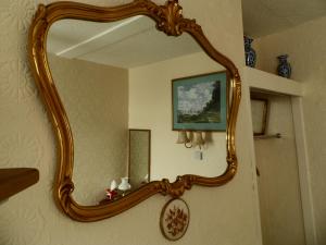 a mirror with a wooden frame hanging on a wall at St Martins Guest House in Dover