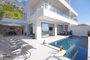 eine Villa mit einem Pool und einem Haus in der Unterkunft Holiday home Anja in Makarska