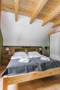 1 dormitorio con cama de madera en una habitación con techo de madera en Ferienwohnungen Orth, en Lassing