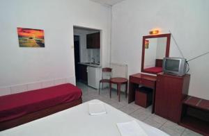 a room with a bed and a tv and a mirror at Chrissafis Hotel in Panagia