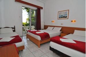 a hotel room with two beds and a window at Chrissafis Hotel in Panagia