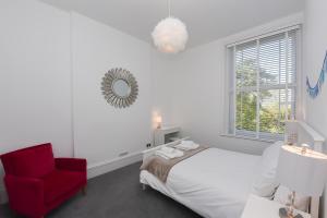 um quarto com uma cama e uma cadeira vermelha em Fantastic Sea View, 1 bed sleeps 2 em Broadstairs