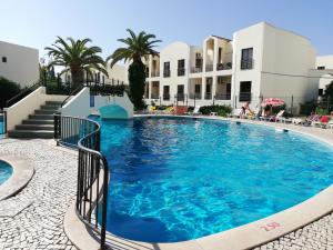 a large swimming pool in front of a building at Alltravel Alvor apartment in Alvor