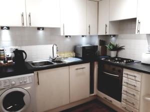 a kitchen with a sink and a washing machine at Riverside Apartment York in York