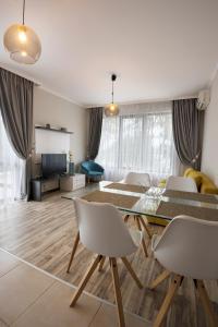 a living room with a table and chairs and a tv at Green Paradise Deluxe Apartments in Primorsko