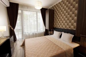 a bedroom with a large bed and a large window at Green Paradise Deluxe Apartments in Primorsko +230 photos