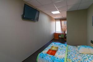 チタにあるHostel Friendsの壁にテレビとベッドが備わる客室です。