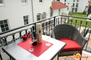 a table with two wine glasses on a balcony at Haus Meeresblick FeWo Leuchtturm A in Baabe