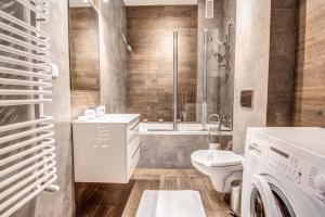 La salle de bains est pourvue d'un lavabo et d'une douche. dans l'établissement Apartamenty Oaza Deluxe Zakopane, à Zakopane