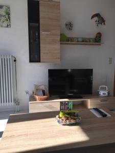een woonkamer met een flatscreen-tv en een tafel bij Ferienwohnung Sonnenschein in Grenzach-Wyhlen