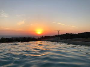 a infinity pool with the sunset in the background at Thea Sunrise Luxury Villa with Heated Eco Pool in Kallithea Rhodes