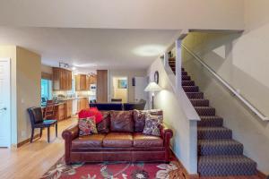 a living room with a couch and a staircase at Pinewood Getaway in Ketchum