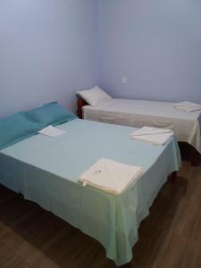 two beds sitting next to each other in a room at Pousada Aconchego in Mateiros