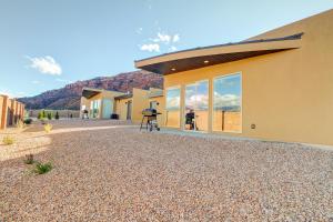 a man sitting on a stool in front of a house at Rim View 2 in Moab