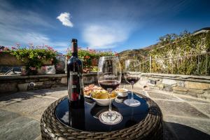 Dois copos de vinho e uma taça de comida numa mesa. em Hotel Lo Fleyé em Saint-Pierre