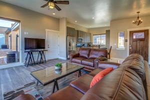 a living room with leather furniture and a table at Rim View 2 in Moab