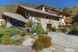 una casa de piedra con un jardín delante de ella en Hotel Lo Fleyé en Saint-Pierre