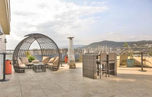un patio con sillas y mesas en la azotea en Swiss Inn Nexus Hotel, en Addis Ababa