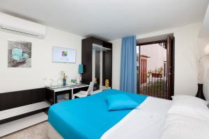 a white bedroom with a blue bed and a sink at Sorrento Flats in Sorrento