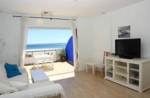 タリファにあるLivingtarifa Apartamento Paradiseのリビングルーム(テレビ付)が備わり、海の景色を望めます。