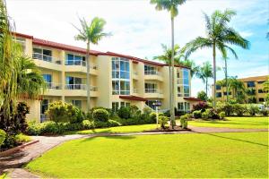 a large building with palm trees and a park at Key Largo Holiday Apartments in Gold Coast