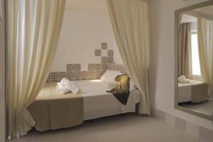1 dormitorio con cama y espejo en Hostal Gravina en Tarifa