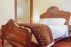 a bedroom with a wooden bed with a large mirror at 57 in Porto